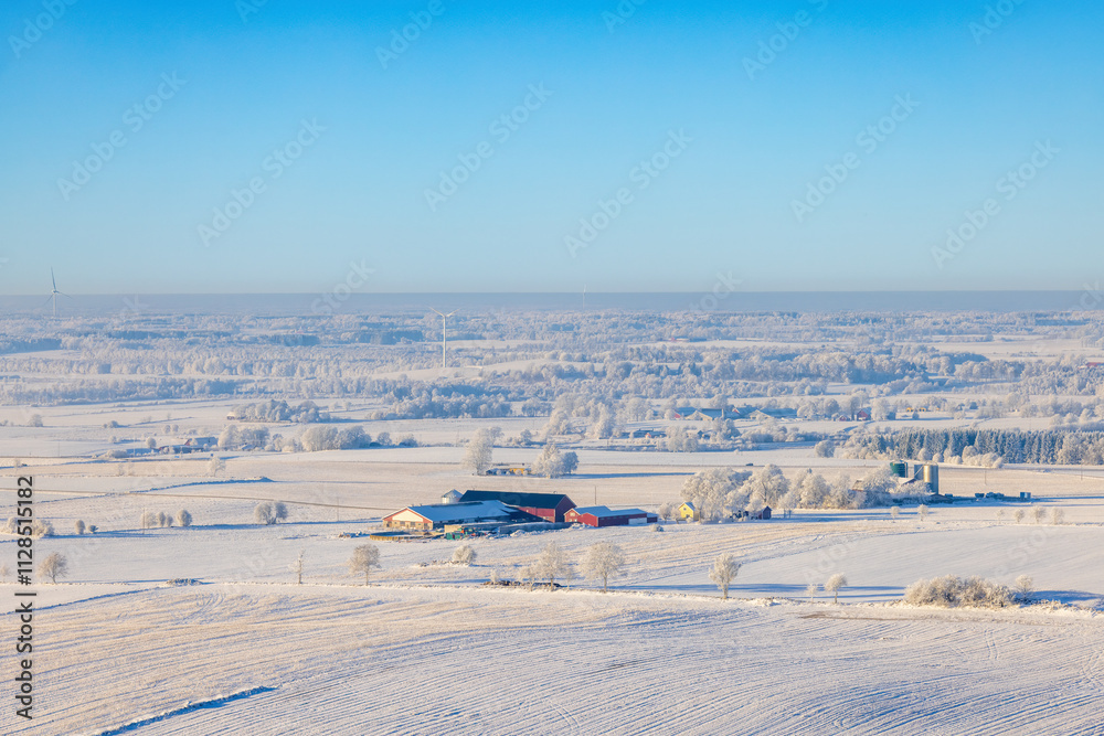Aerial view at a farmstead in a wintry rural landscape with snow on the fields Aerial view at a farmstead in a wintry rural landscape with snow on the fields
