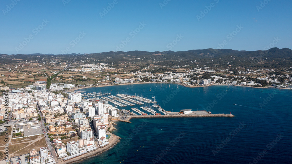 Aerial drone photo of a beach in the town of Sant Antoni de Portmany on the island of Ibiza in the Balearic Islands Spain showing the boating harbour and the beach known as Playa de San Antonio