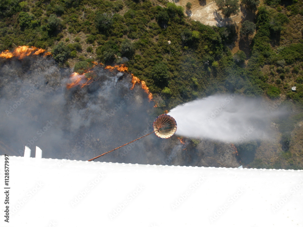 Firefighting Helicopter Dumps Buckets of Water to Extinguish a Forest Fire