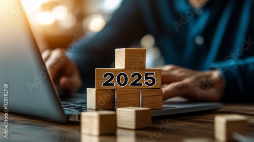 2025 New Year Celebration - Wooden Number Blocks, a businessman working with a laptop and building block stacks up to the number 