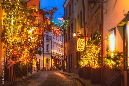 Vilnius, Lithuania - 30th november, 2024: Wonderful creative Christmas decorations on famous stikliai street in Vilnius old town. Holidays decorations. Bright lights decor by cafes and restaurants photo