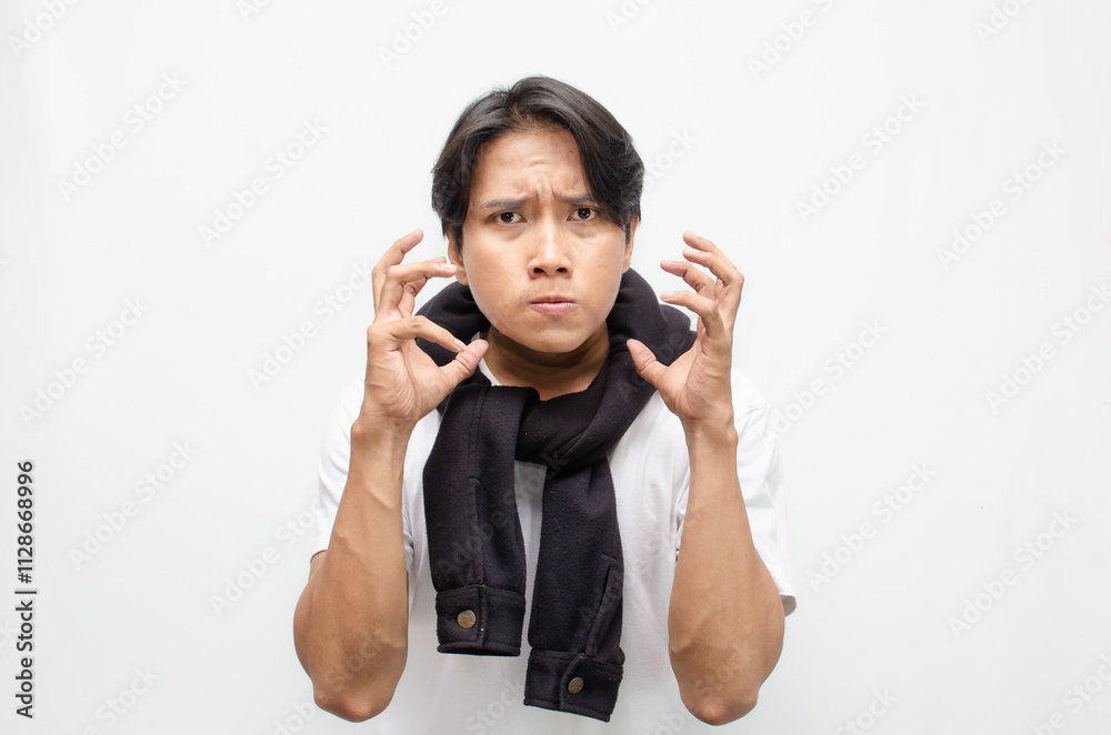 Angry Young Asian Man Shouting and Clenching His Fist in Rage Angry Young Asian Man Shouting and Clenching His Fist in Rage