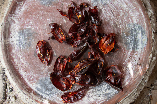 Preparing Mexican Mole Negro. Oaxaca chiles have to be cleaned, toasted on a comal over a flame and soaked in water before grinding with metate. photo