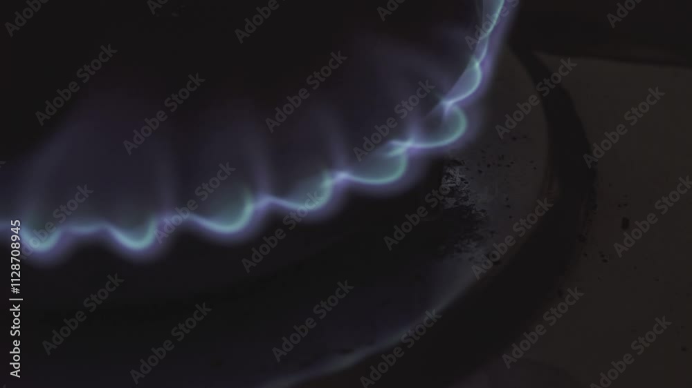 Gas burner burning with blue flames on stovetop Gas burner burning with blue flames on stovetop