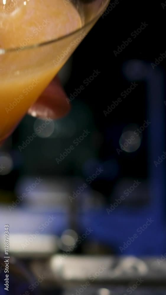 Bartender pouring martini in a cocktail glass in slow motion. Alcohol slowly pours on green olives in the glass. Bartender pouring martini in a cocktail glass in slow motion. Alcohol slowly pours on green olives in the glass.