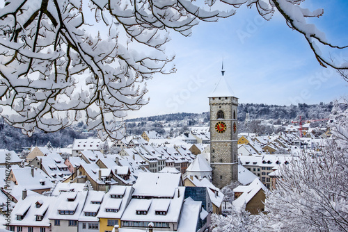 The St. Johan church tower over the old town roofs after a winter snow fall in Schaffhausen, Switzerland photo