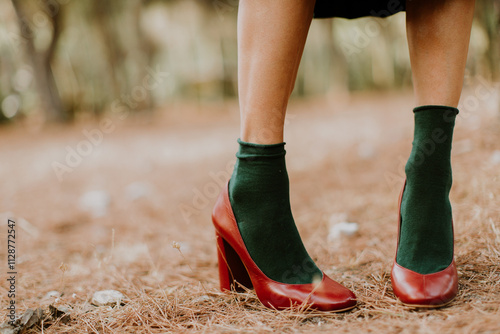 Close-up of a woman's legs standing outdoors wearing ankle socks and high heel shoes photo