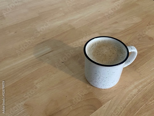 Rustic Speckled Mug of Frothy Coffee on Wooden Table