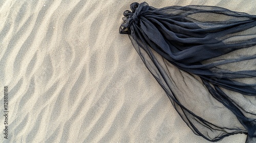 Dark Netting on Sandy Beach, Textured Fabric and Rippled Sand photo