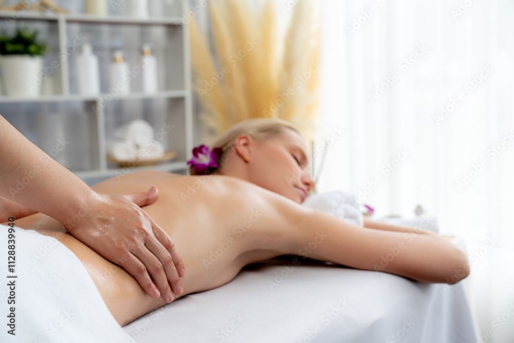 Caucasian woman customer enjoying relaxing anti-stress spa massage and pampering with beauty skin recreation leisure in day light ambient salon spa at luxury resort or hotel. Quiescent Caucasian woman customer enjoying relaxing anti-stress spa massage and pampering with beauty skin recreation leisure in day light ambient salon spa at luxury resort or hotel. Quiescent
