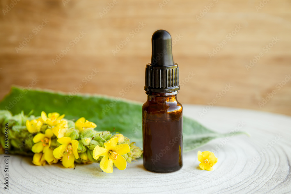 Homemade herbal medicinal tincture made of Verbascum thapsus, the great mullein, greater mullein or common mullein. Yellow flower branch with pipette bottle composition on wood background. Homemade herbal medicinal tincture made of Verbascum thapsus, the great mullein, greater mullein or common mullein. Yellow flower branch with pipette bottle composition on wood background.