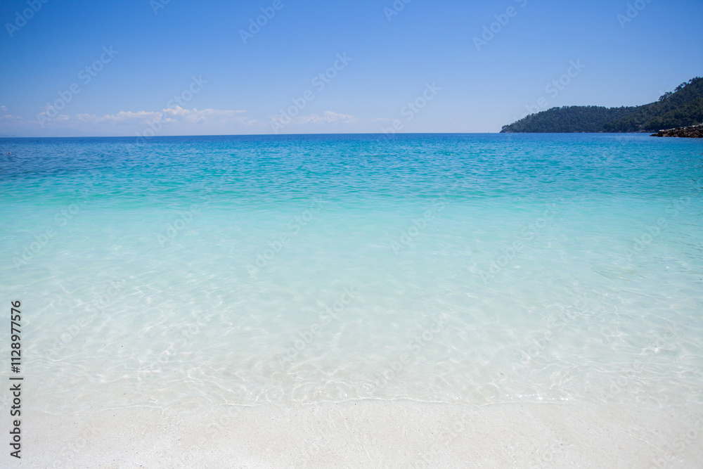 Breathtaking view of crystal-clear turquoise water gently lapping against a pristine shoreline. Breathtaking view of crystal-clear turquoise water gently lapping against a pristine shoreline.