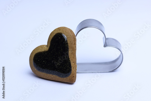 Gingerbread heart and cookie cutter on white background. Valentine's day concept.