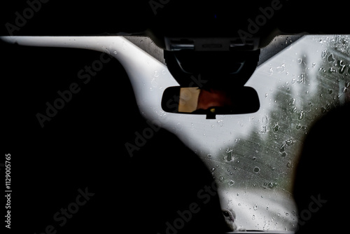 Obstructed view from the back seat of a vehicle with rain falling on the front window. photo