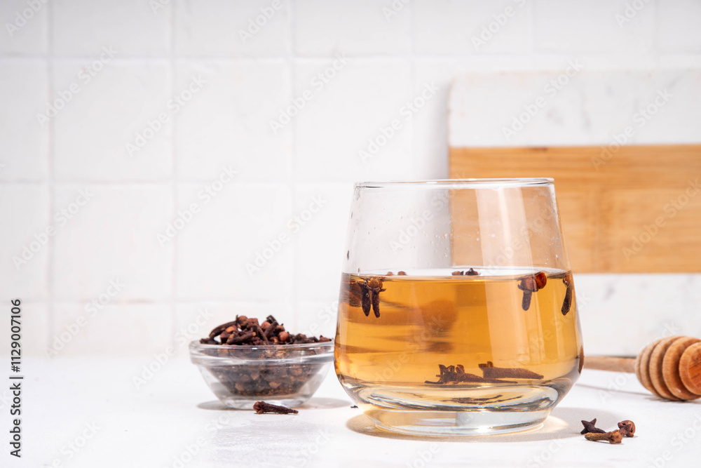 Clove Water or Tea, organic infused drink. Ayurvedic, antiseptic, anti-inflammatory and antioxidant drink, brewed dry clove remedy in glass Clove Water or Tea, organic infused drink. Ayurvedic, antiseptic, anti-inflammatory and antioxidant drink, brewed dry clove remedy in glass