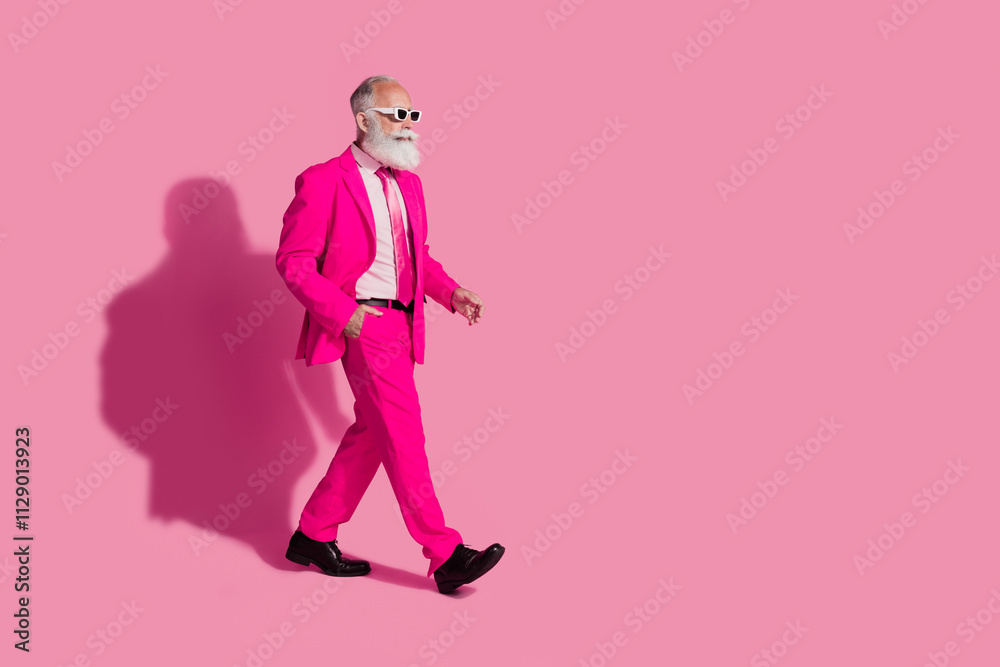 Full size photo of cool santa claus male macho walking dressed sunglass trendy pink suit isolated over pastel color background Full size photo of cool santa claus male macho walking dressed sunglass trendy pink suit isolated over pastel color background