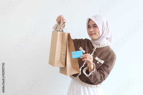 Smiling Muslim Woman with Shopping Bags and Credit Card Happy Online Shopping Experience photo