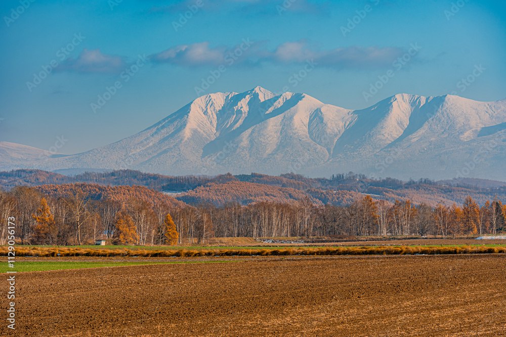 Obraz premium 北海道の雪化粧の旭岳と紅葉/Snow-capped Mount Asahidake and autumn leaves in Hokkaido