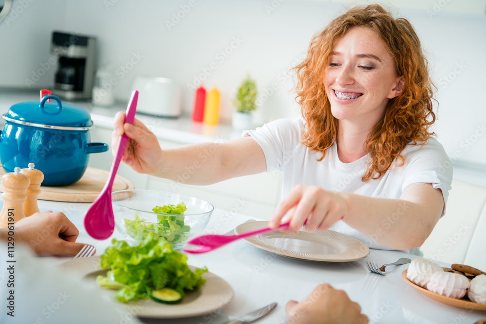 Young woman with red hair cooking indoors, cheerfully preparing breakfast in casual style kitchen Young woman with red hair cooking indoors, cheerfully preparing breakfast in casual style kitchen