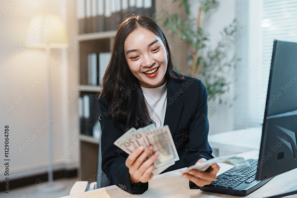 Young businesswoman smiling and counting hong kong dollar banknotes at her office desk Young businesswoman smiling and counting hong kong dollar banknotes at her office desk
