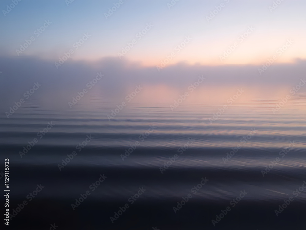 Obraz premium Gentle ripples on a calm lake at dawn, with fog and subtle pink and blue tones in the air