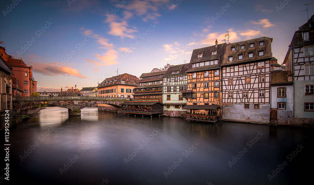 Obraz premium Beautiful reflections of traditional buildings on the river in Strasbourg during sunset
