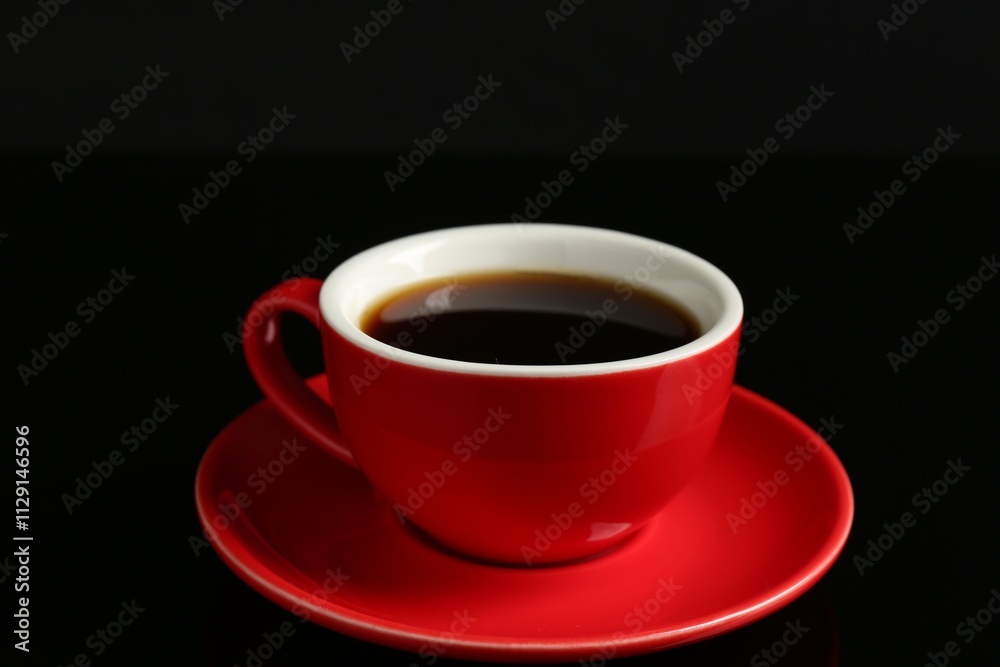 Red cup with coffee on black background, closeup Red cup with coffee on black background, closeup