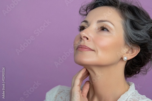 A mature woman with olive skin, wearing pearl earrings, one hand lightly touching her neck, soft purple background, even studio lighting 3 photo