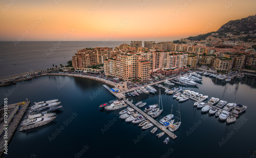 Fototapeta premium Luxury yachts docked at a marina during sunset in a coastal city