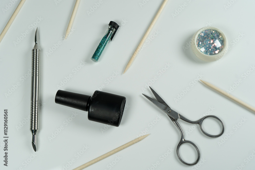 A flat-lay composition for a manicure professional, featuring tools like scissors, gel polish, and cuticle sticks. A flat-lay composition for a manicure professional, featuring tools like scissors, gel polish, and cuticle sticks.
