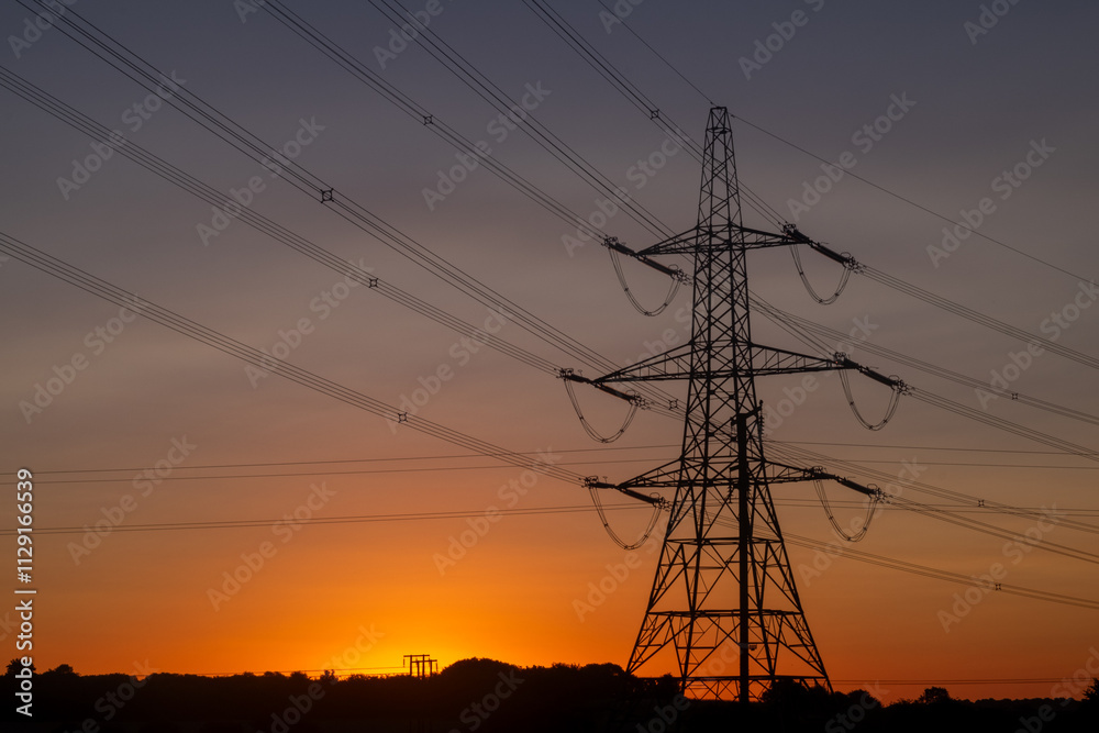 Electricity pylon and power lines at sunrise Electricity pylon and power lines at sunrise