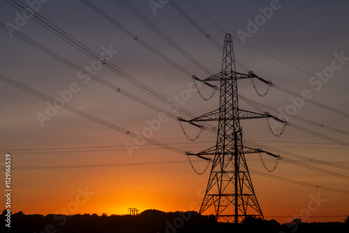 Electricity pylon and power lines at sunrise