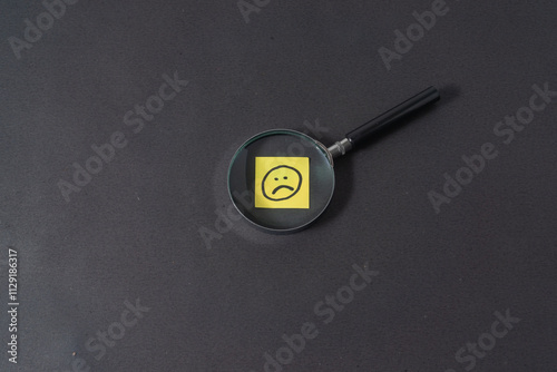 Magnifying glass with a sad emoji