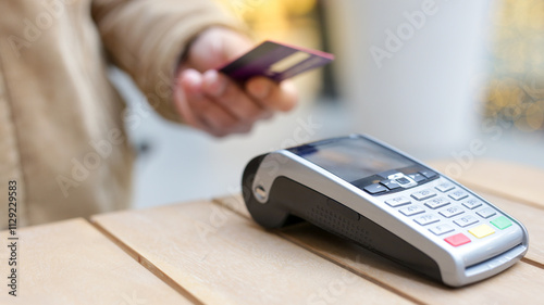 Person paying with contactless credit card at pos terminal