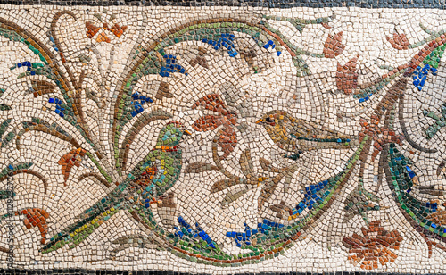 Close-up on ancient mosaic representing little birds amongst flowers and plants