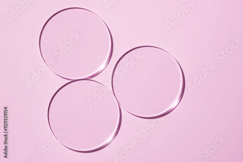 Empty Petri dishes on a pink background. Bright sunlight. Deep shadows. Contrast. Laboratory. cosmetic lab item, round transparent glass dish photo