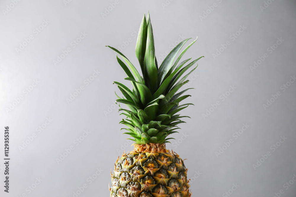 Fresh ripe pineapple on light grey background, closeup Fresh ripe pineapple on light grey background, closeup