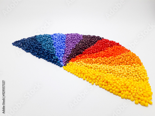 Various colors of masterbatch granules arranged on a white background, polymer carrier of color pigments in the plastic industry. Suitable for plastic company catalog design