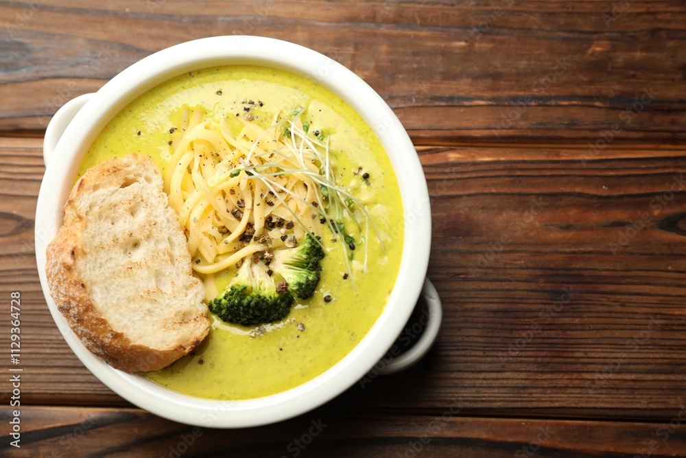Delicious broccoli cream soup and crouton in bowl on wooden table, top view. Space for text Delicious broccoli cream soup and crouton in bowl on wooden table, top view. Space for text