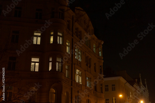 A somewhat blurry photograph captures a building illuminated by bright lights during the night, creating a captivating atmosphere