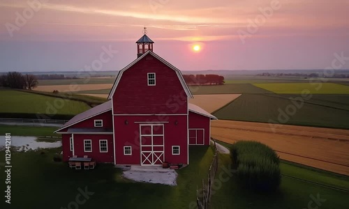 Red barn at sunset in scenic countryside video animation. Classic farm building evening rural landscape animated footage HD clip seamless motion graphics. Agricultural farmland concept