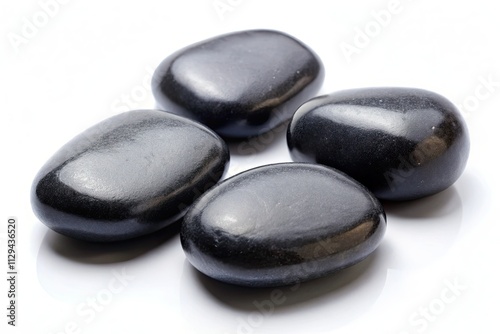 Four smooth, black pebbles isolated on white, viewed from above.  A perfect stock photo.