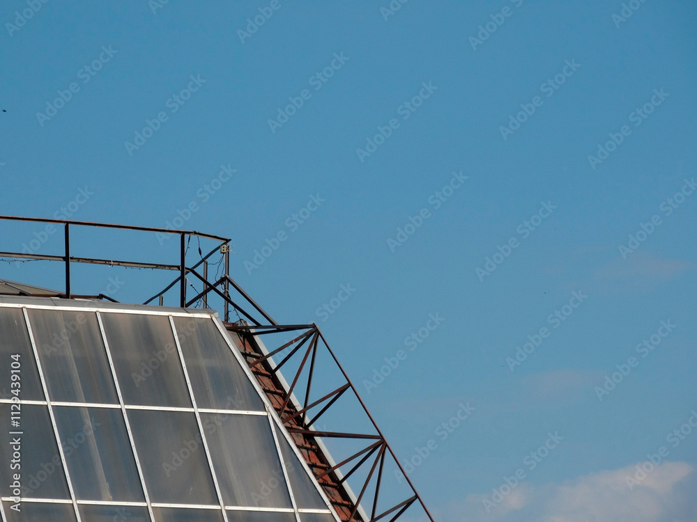 Image of a partially constructed or renovated industrialcommercial building with a large glass dome, clear sky backdrop, and slight distortion Image of a partially constructed or renovated industrialcommercial building with a large glass dome, clear sky backdrop, and slight distortion