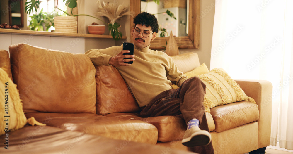 Man, phone and texting on sofa, relax and reading in living room, chat and mobile app in home. Person, smartphone and check notification with contact on lounge couch with social network at apartment Man, phone and texting on sofa, relax and reading in living room, chat and mobile app in home. Person, smartphone and check notification with contact on lounge couch with social network at apartment