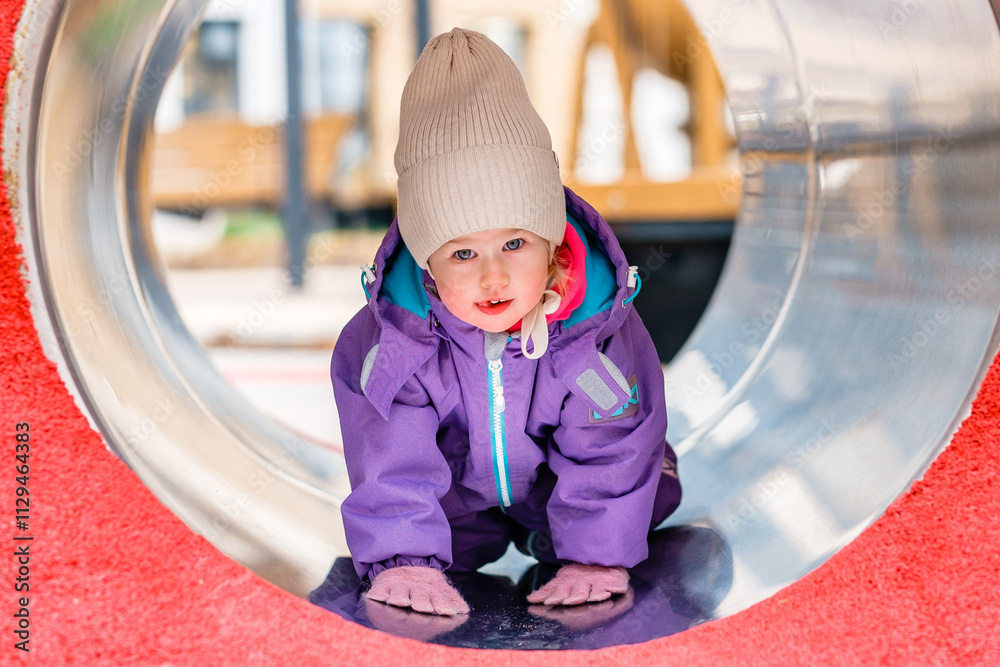 Cute child Caucasian two-year-old girl on the playground. Cold season. Cute child Caucasian two-year-old girl on the playground. Cold season.