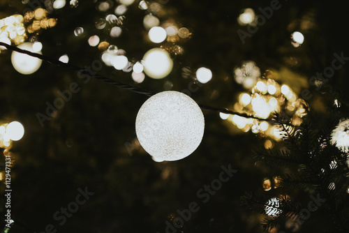 Gold Christmas tree decorations close-up on a spruce with a garland and with gifts for Xmas photo