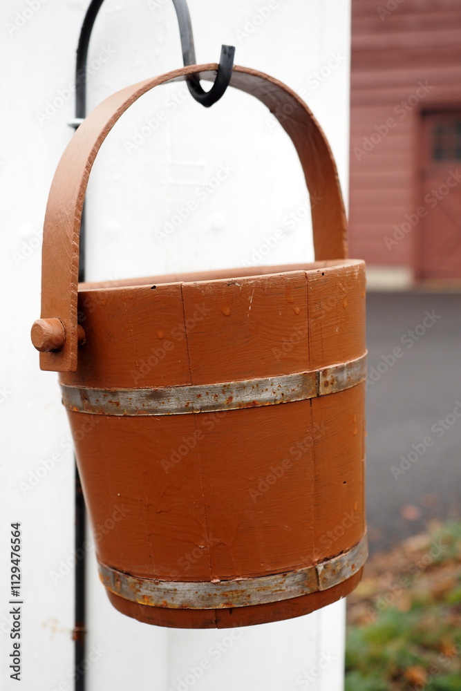 The water bucket is next to the old water pump. The water bucket is next to the old water pump.