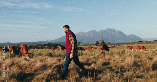 Man, farmer and walking with livestock on grass field for natural production, agriculture or agro business in nature. Male person, animals and farmland with sustainability for faming in countryside photo