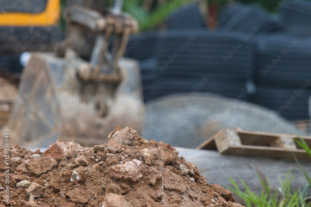 Naklejka premium A pile of dirt with a large piece of equipment in the background