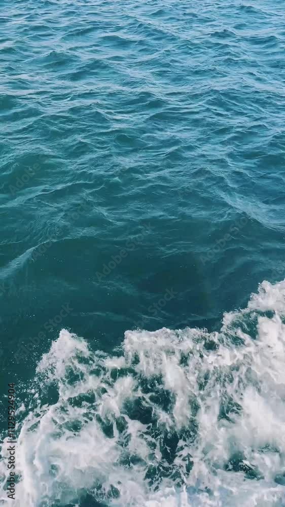 Calm ocean waves gently lapping against a boat during a bright sunny day near the coast Calm ocean waves gently lapping against a boat during a bright sunny day near the coast